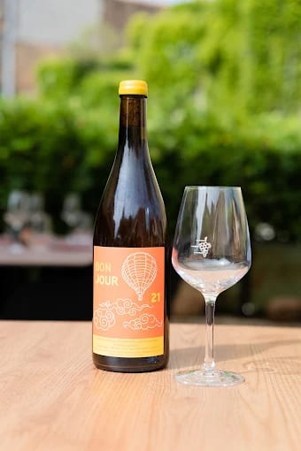 Bouteille de vin nature et verre en terrasse